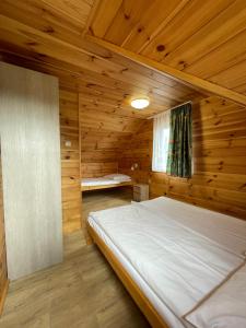 a bedroom with a bed in a wooden room at Ośrodek Szeligi in Ełk