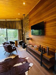 Una televisión o centro de entretenimiento en Requinte dos Pinhais Chalé Rubi