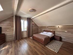a bedroom with a bed and a large window at Ethno Complex Ukrayinske Selo in Buzovaya