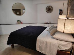 a bedroom with a bed and a mirror and a clock at Tiny House in Guanajuato