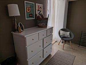 a dresser with a lamp and a chair in a room at Tiny House in Guanajuato +1 photo