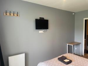 a bedroom with a bed and a tv on the wall at Mini Studio avec Terrasse in Aurillac