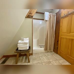 a bathroom with a shower and a pile of towels at A-Frame #15 - by The Chalets in Logan