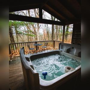 a hot tub on a deck with a table at A-Frame #17 - by The Chalets in Logan +9 photos