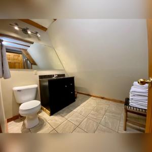 a bathroom with a toilet and a sink at A-Frame #18 - by The Chalets in Logan +9 photos