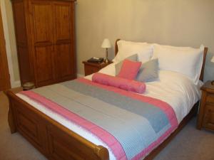 a bed with colorful pillows on it in a bedroom at The Paddock in Haverfordwest
