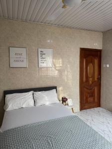 a bedroom with a bed and a wooden door at Cozy 2 bedroom apartment in Accra