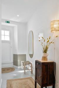 a room with a mirror and a table with a vase on it at Amber and Rust Estremoz City House in Estremoz
