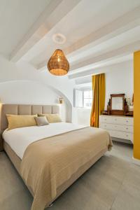 a bedroom with a large bed and a chandelier at Amber and Rust Estremoz City House in Estremoz