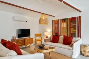 a living room with two white couches and a tv at Amber and Rust Estremoz City House in Estremoz