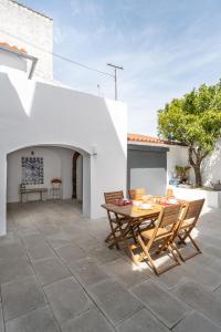 a patio with a wooden table and chairs at Amber and Rust Estremoz City House in Estremoz