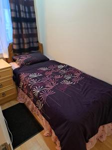 a bedroom with a bed with a purple comforter at Ilford Town House- Close to London ILFORD Train Station in Ilford +15 photos