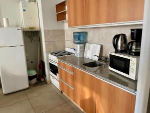 a kitchen with a white refrigerator and a sink at 3-Genial dpto morón centro in Morón