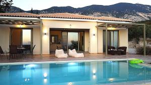 a swimming pool in front of a house at ReLux Villa in Kefallonia