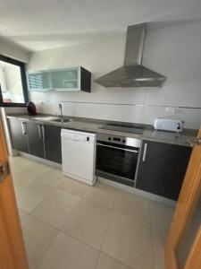 a kitchen with a sink and a stove top oven at Kronos Apartment in Benidorm