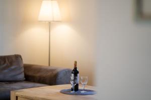 Una botella de vino y dos copas en una mesa de café. en Chalet Ostsee A, en Dahme