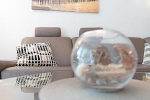 a glass vase sitting on a table in front of a couch at Strandvilla Augustusbad Ostseeparadies in Scharbeutz