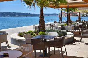 a restaurant with tables and chairs next to the water at Apartment Castellina in Kaštela