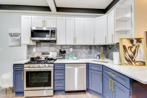 a kitchen with blue cabinets and a stove top oven at Newly Renovated Abode with Patio in Baltimore! in Baltimore