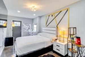 a bedroom with a white bed and a tv at Newly Renovated Abode with Patio in Baltimore! in Baltimore