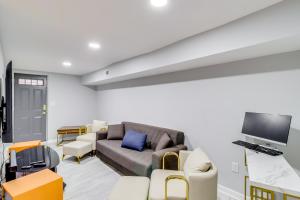 a living room with a couch and a tv at Newly Renovated Abode with Patio in Baltimore! in Baltimore