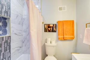 a bathroom with a shower curtain and a toilet at Newly Renovated Abode with Patio in Baltimore! in Baltimore