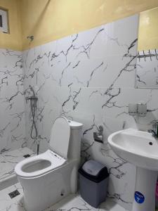a white bathroom with a toilet and a sink at ADORA HOSTEl in Tashkent