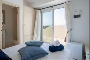 une chambre avec un lit et une grande fenêtre dans l'établissement Incantevole Appartamento a Porto Cervo, à Liscia di Vacca