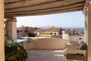 d'une terrasse sur le toit avec un canapé et des chaises. dans l'établissement Incantevole Appartamento a Porto Cervo, à Liscia di Vacca