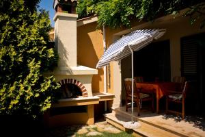 eine Terrasse mit einem Tisch und einem Sonnenschirm neben einem Haus in der Unterkunft Villa Dolores in Rovinj