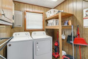 a kitchen with a washing machine and a wooden wall at Lakefront Gem with Boat Dock and Fishing Pier in Many in Many