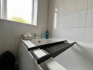 a white bathroom with a tub and a sink at Spacious House Close to Central Manchester With Free Parking in Manchester +23 photos