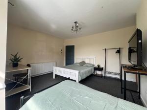 a bedroom with two beds and a flat screen tv at Spacious House Close to Central Manchester With Free Parking in Manchester