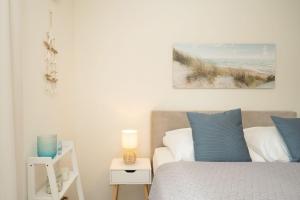 a bedroom with a bed with blue and white pillows at Pier 67 Ostseeglück Neustadt in Roge +34 photos