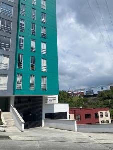 a large green building with a parking lot at CC Fundadores, cerca sector el Cable y CC Mall Plaza in Manizales