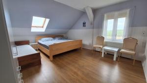 a bedroom with a bed and two chairs at Agroturystyka nad stawem Mazuchówka in Wydminy