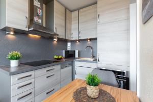 a kitchen with white cabinets and a wooden table at Meerblick mit Wohlfühlfaktor in Staberdorf