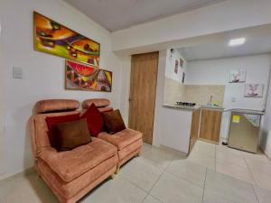 ein Wohnzimmer mit Couch und Küche in der Unterkunft Increible Apto 10Min Base Aérea - Aquaparque Caña in Cali
