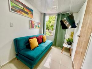 ein blaues Sofa in einem Zimmer mit Fenster in der Unterkunft Increible Apto 10Min Base Aérea - Aquaparque Caña in Cali