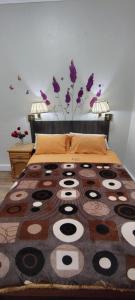Un dormitorio con una cama grande con una manta encima. en Hospedaje CASA REAL, en Huancayo