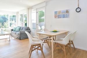a kitchen and living room with a table and chairs at Am Schoor Bungalow 12 in Grömitz