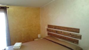 a bedroom with a bed with a wooden headboard at Appartamento Villa Elison in Lazise +42 photos