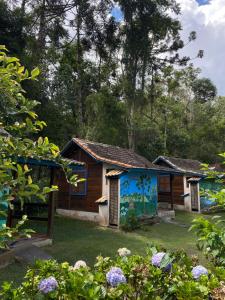 a small house with a painting on the side of it at Pousada Cabanas do Visconde in Visconde De Maua +16 photos