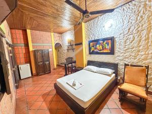 a bedroom with a bed and a chair in it at Hotel Casa Madrid in Puerto Berrío