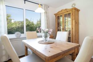 a dining room table with chairs and a vase of flowers at Bungalow Zwergenweg 2b in Grömnitzerhagen