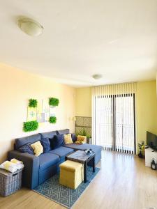 Una sala de estar con un sofá azul y una mesa. en Апартамент “Централ” / Central, en Balchik