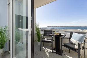 a balcony with a table and chairs and a view of the ocean at Aloha Suite in Fehmarn +27 photos