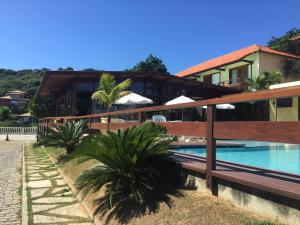 a resort with a swimming pool and a building at Barlavento Suites in Búzios