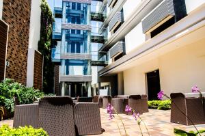 a row of chairs and flowers in front of a building at Hotel CasaBlanca Cucuta in Cúcuta