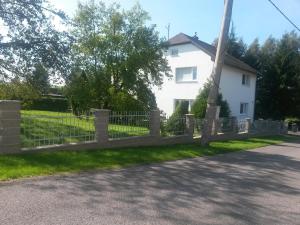 una cerca frente a una casa blanca en Ubytování Chadimovi en Šluknov